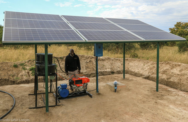 A man standing next to a solar-powered water pump in Hwange National Park
