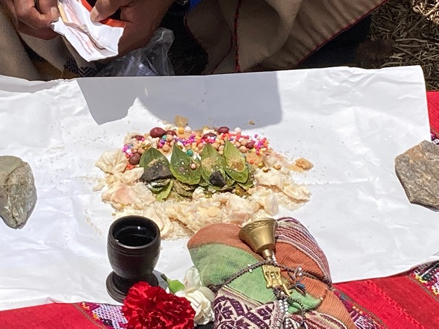 A bundle of offerings to the gods during a Pachamama ceremony, including coca leaves, spices candies, llama fat, beans, and confetti