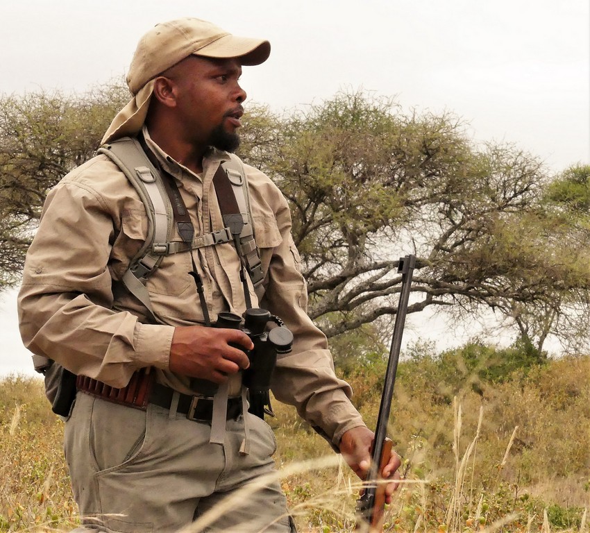 A safari guide walking with a rifle in Tarangire National Park, Tanzania