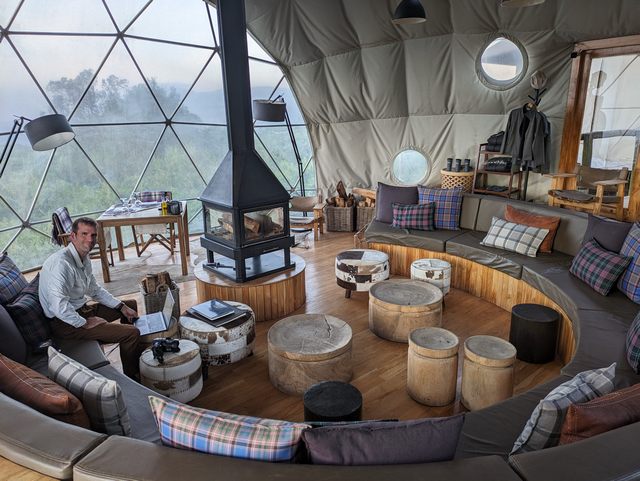 A man relaxing in the beautiful common area at Asilia's luxurious Highlands Camp at Ngorongoro Crater Tanzania
