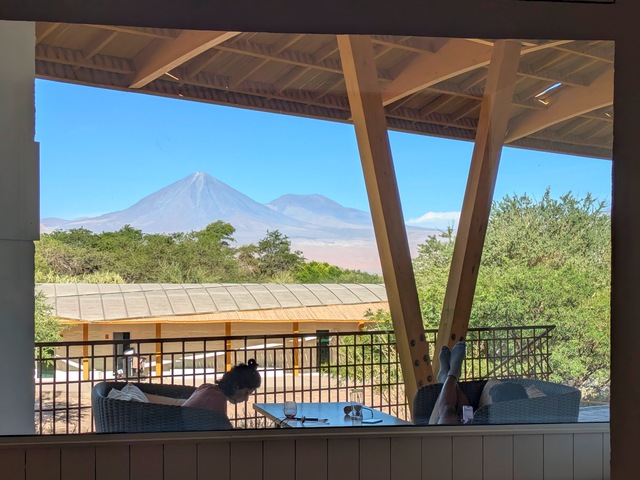 Guest sitting on patio at Explora Atacama with Volcan Licancabur in the background