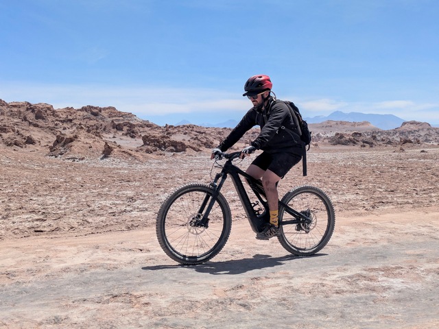 a man riding across sand and rocks in the Salt Valley of the Atacama
