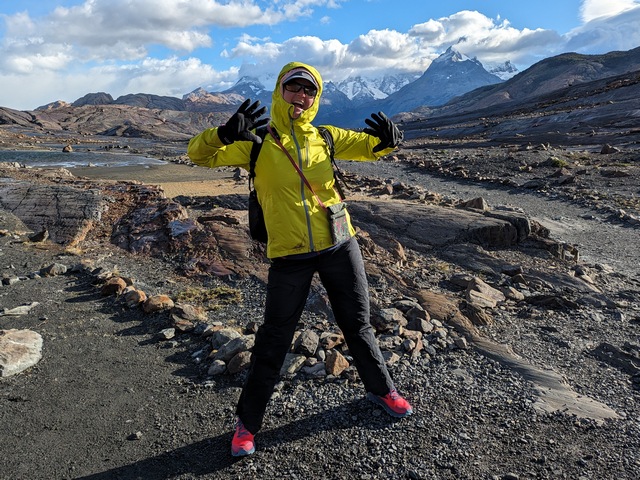 woman modeling rain jacket and gloves in mountains of Patagonia