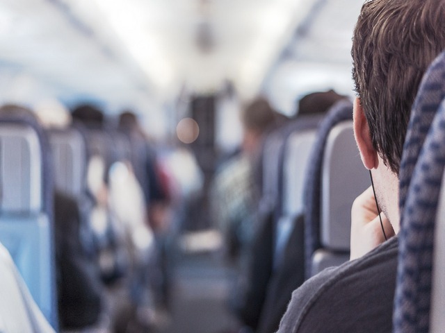 interior view of airplane, with person's head in focus looking toward front of plane