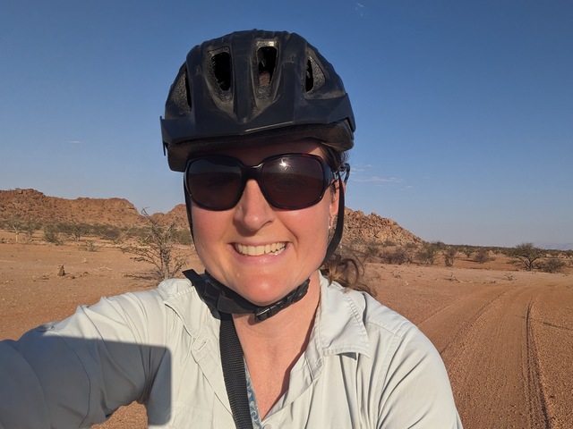 selfie of a woman riding an e-bike across the desert landscapes at Onduli Ridge Camp, a luxury safari camp in Damaraland, Namibia