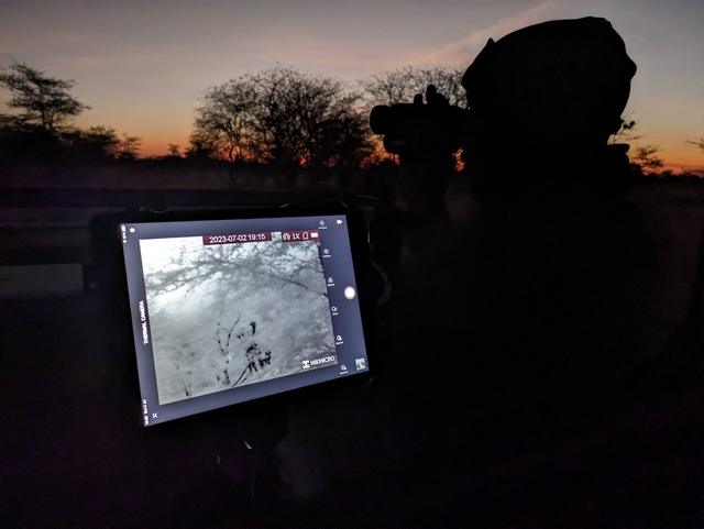 Using thermal monocular technology to spot wildlife at night on a game drive at the luxurious Usangu Expedition Camp in Ruaha National Park Tanzania
