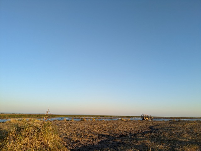 A lone safari vehicle from Asilia's Usangu Expedition Camp is dwarfed by the endless plains and sky around it in Tanzania's Ruaha National Park