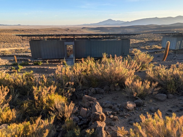 Outside view of Explora Chituca lodge at sunset, with colorful grasses and distant mountains