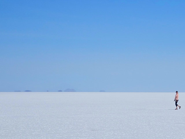 a woman hiking on the vast flat expanses of the uyuni salt flats