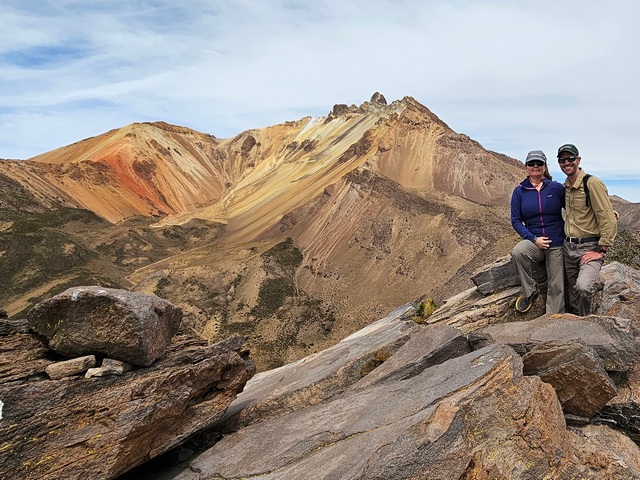 two hikers posed with a view of volcan tunupa in colchani