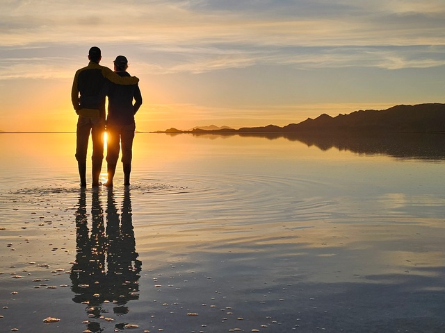 a couple enjoying a romantic sunset and the mirror effect on the uyuni salt flats