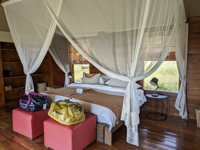 two patagonia black hole duffel bags at the foot of the bed in a luxury safari camp in africa