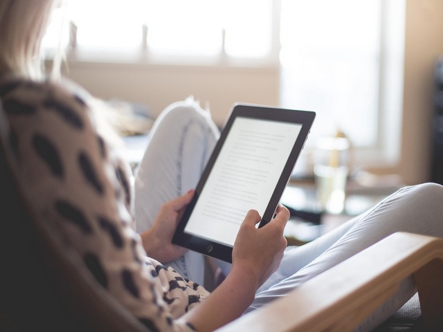 a woman reading using an e-reader
