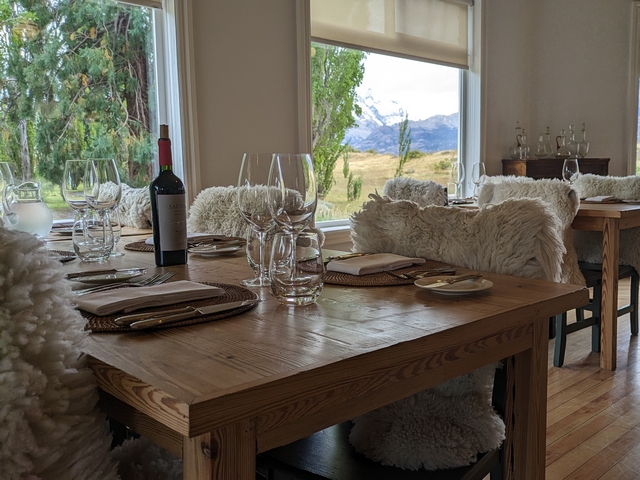 a dining table at estancia cristina, set with wine glasses and sheepskin seat covers
