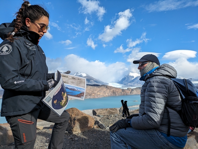 A hiking guide from estancia cristina shows a guest images of glaciers during a guided tour of the upsala glacier