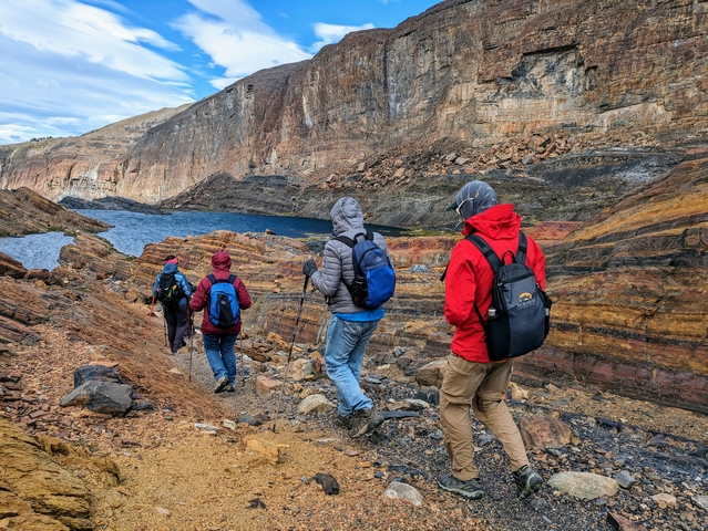 Four hikers descending into the colorful, banded canyon walls of the fossil canyon hike at estancia cristina