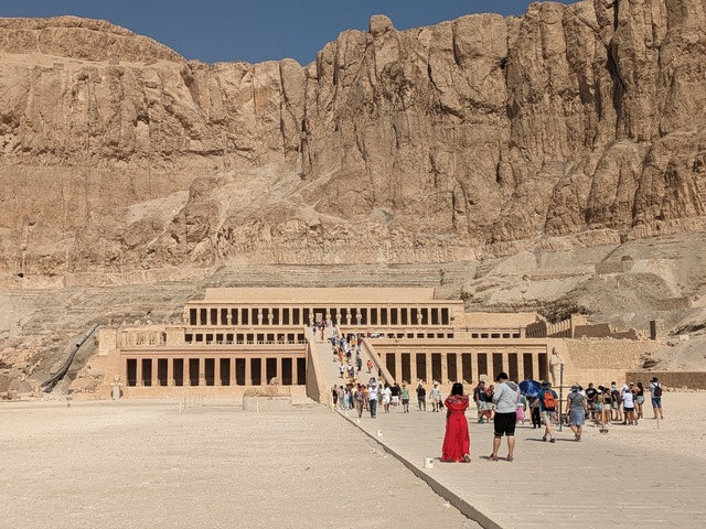 a throng of visitors in front of hatshepsut's temple in egypt