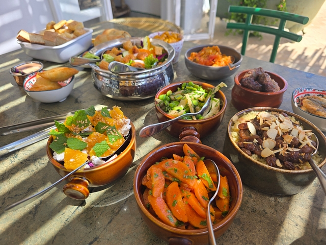 table filled with small dishes of Moroccan foods, including fresh salads, meats, and vegetables