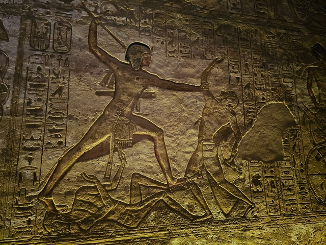 Stone relief carving inside the Great Temple of Abu Simbel, Egypt, showing a larger-than-life Ramesses II slaying one enemy while trampling another at the Battle of Kadesh.