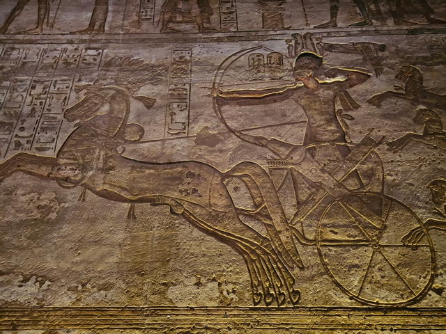 Wall carving inside Great Temple of Abu Simbel, showing Ramesses II firing a bow and arrow from a chariot.