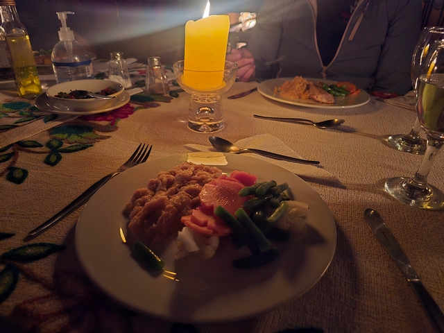 Candlelit dinner inside of Chillca Lodge, showing a candle burning and a plate of food.
