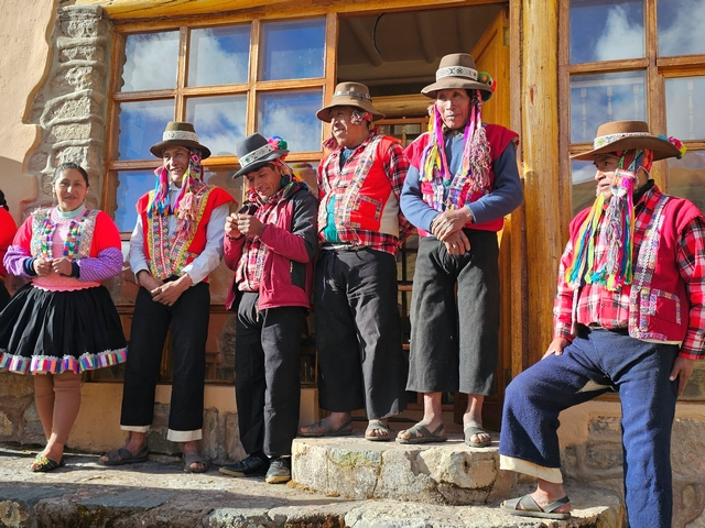 Andean Lodges staff stand outside Chillca Lodge in their colorful traditional dress, including colorful, hand-woven garments and traditional hats.